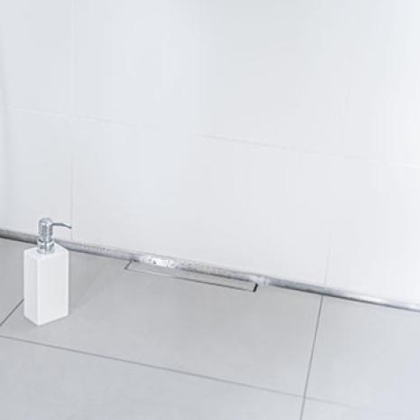Przykład renowacji wąskiej i długiej łazienki: Natrysk bez barier w siedzibie stowarzyszenia „W4H” z odpływem liniowym Dallmer „CeraWall”